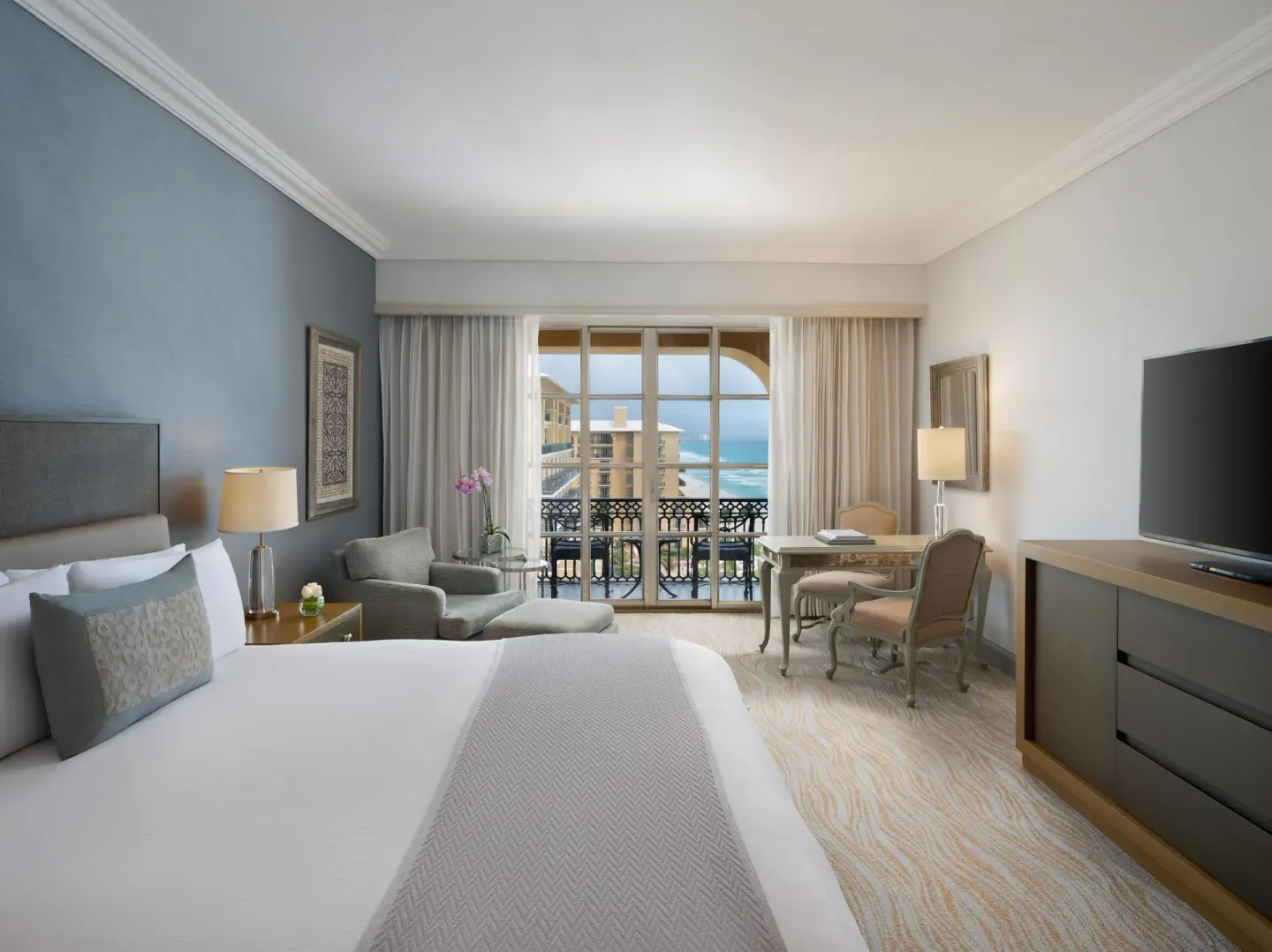 Ocean-view guest room with a king bed and sitting area at Kempinski Hotel Cancún.