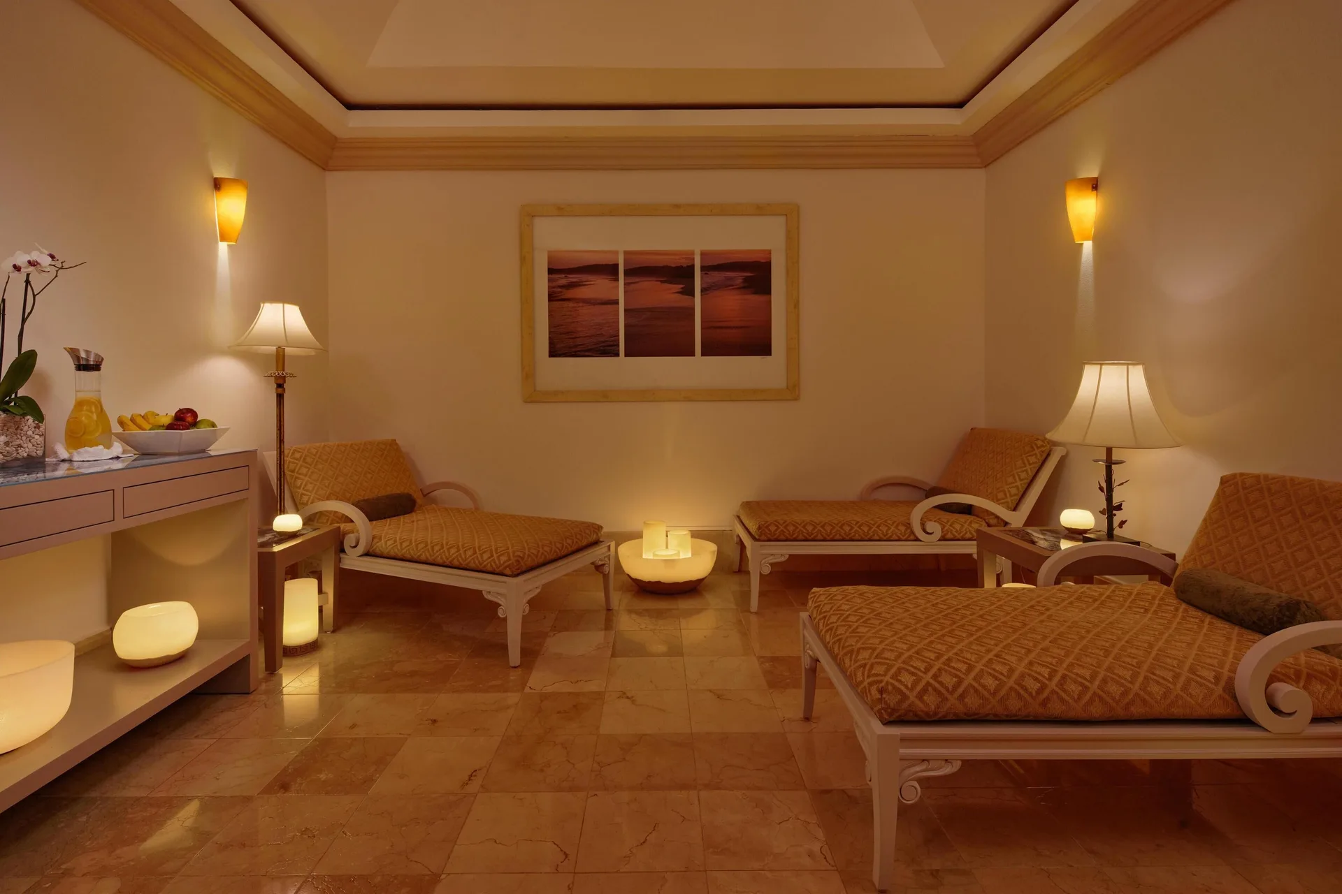 Spa relaxation room with cushioned loungers and candles at Kempinski Hotel Cancún.
