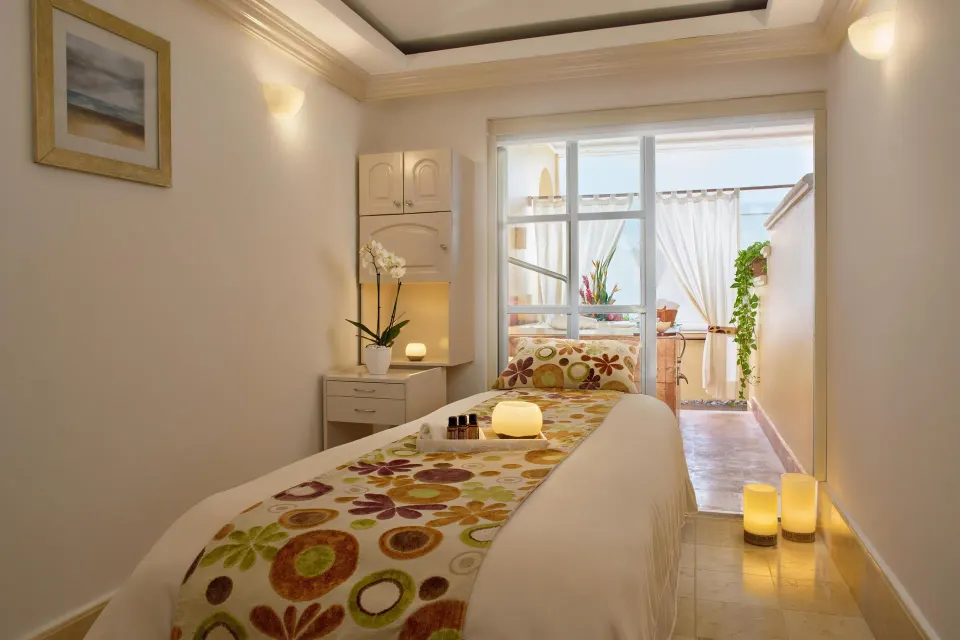 Spa treatment bed with candles and flowers inside Kempinski Hotel Cancún.