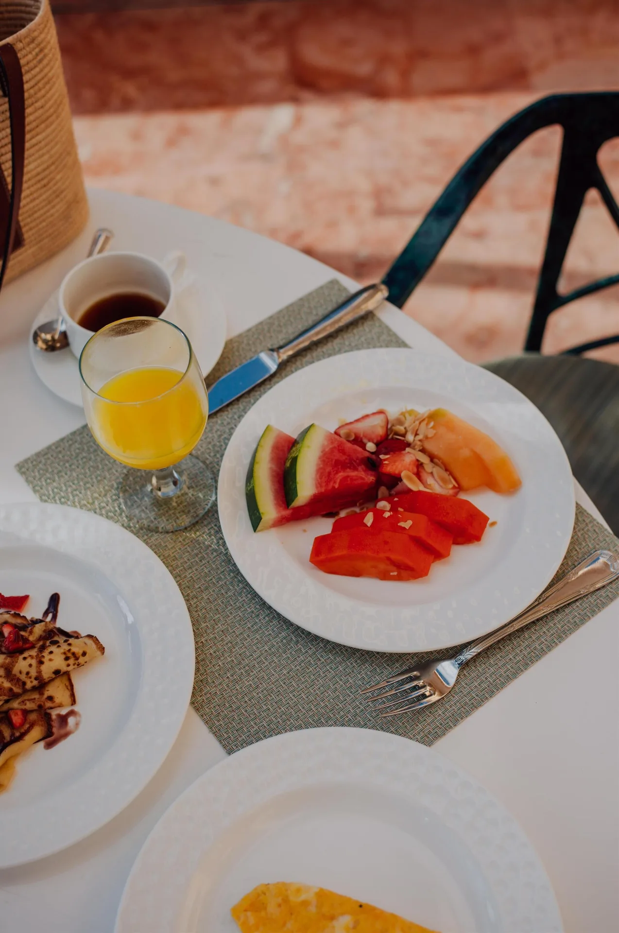 Breakfast table with fruit, juice, coffee and plated dishes at Kempinski Hotel Cancún.