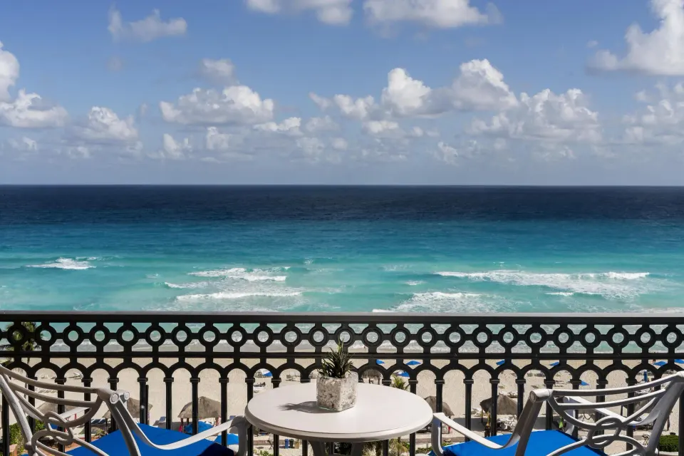 Seafront balcony with chairs and Caribbean water at Kempinski Hotel Cancún.