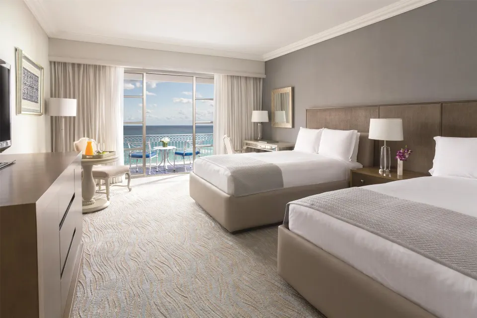 Deluxe seafront room with two beds and ocean-facing balcony at Kempinski Hotel Cancún.