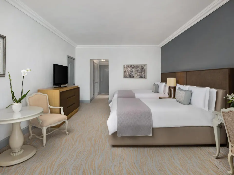 Deluxe seaside guest room with two beds and seating at Kempinski Hotel Cancún.