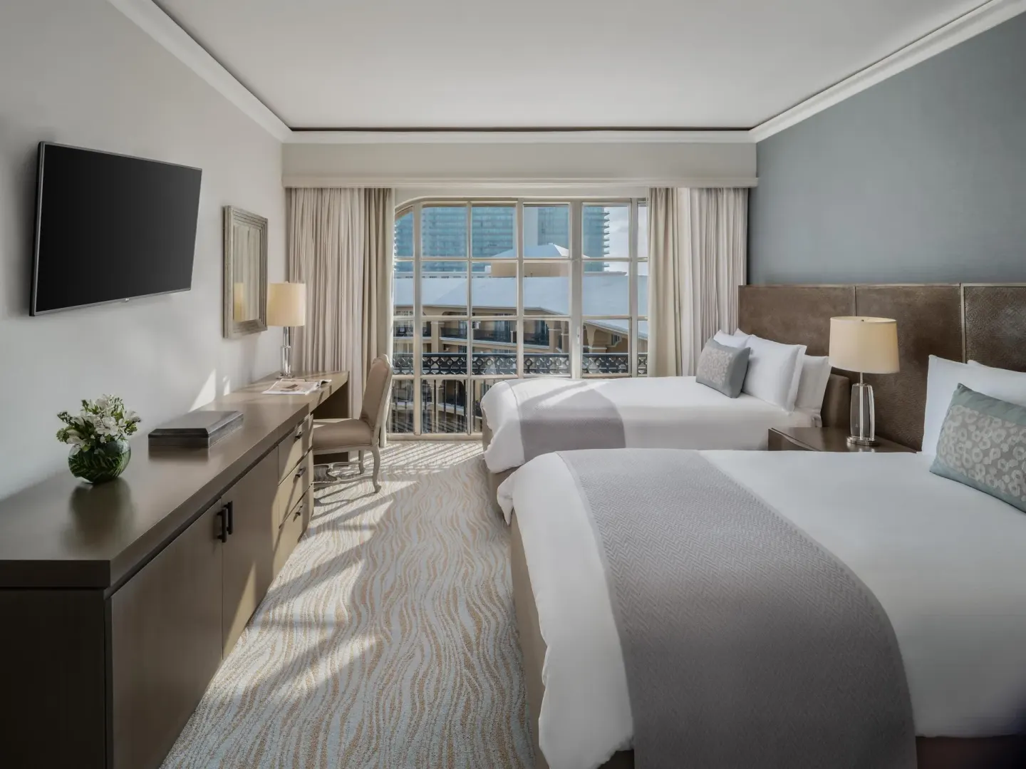 Deluxe seaside guest room with two beds and sunny windows at Kempinski Hotel Cancún.