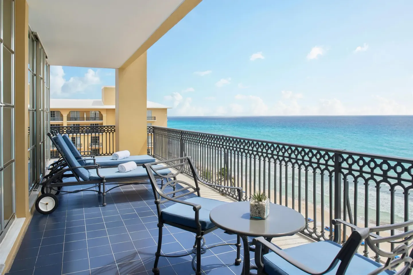 Panoramic Suite balcony with lounge chairs and Caribbean Sea view at Kempinski Hotel Cancún.