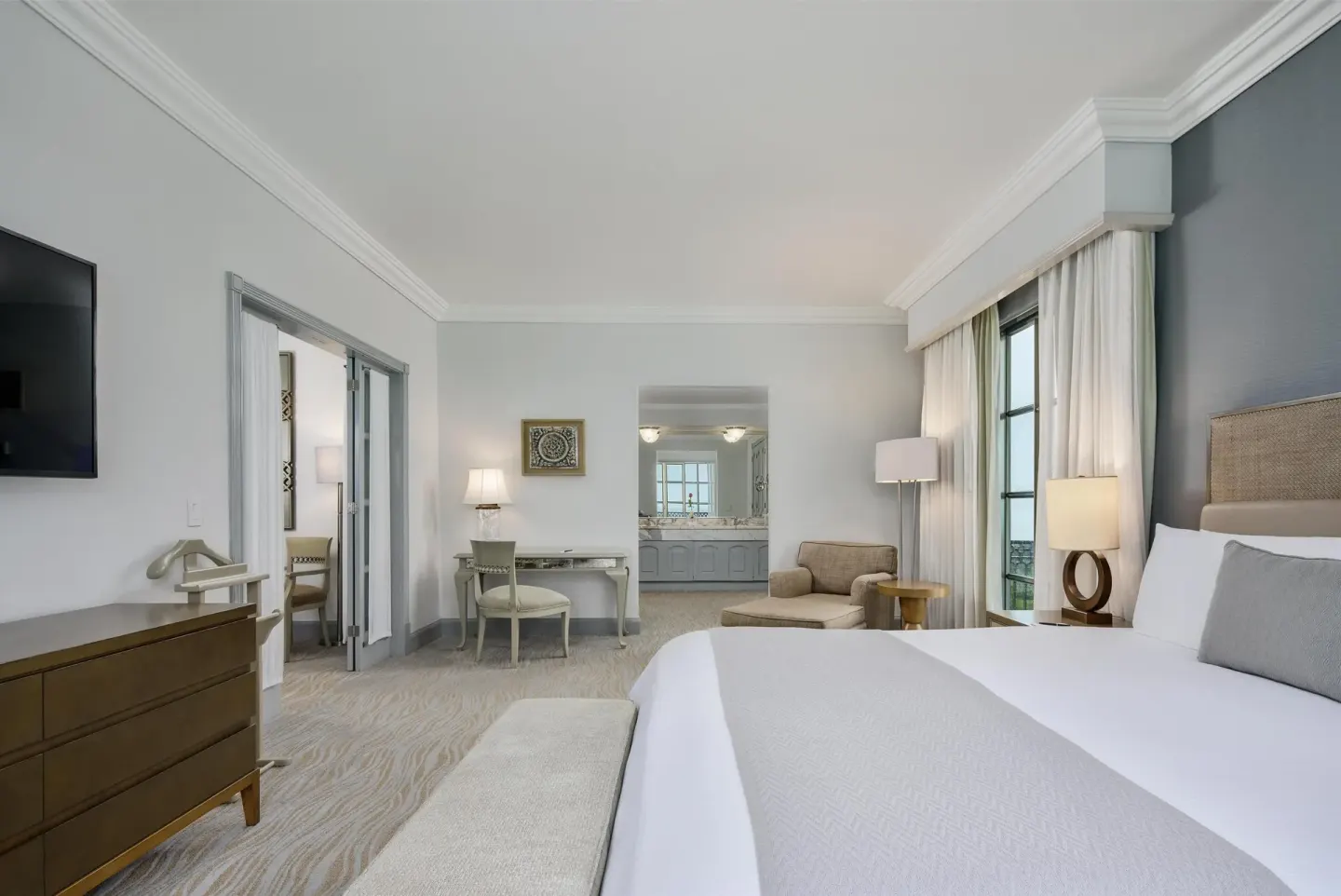 Panoramic Suite bedroom with king bed, seating area and vanity view at Kempinski Hotel Cancún.