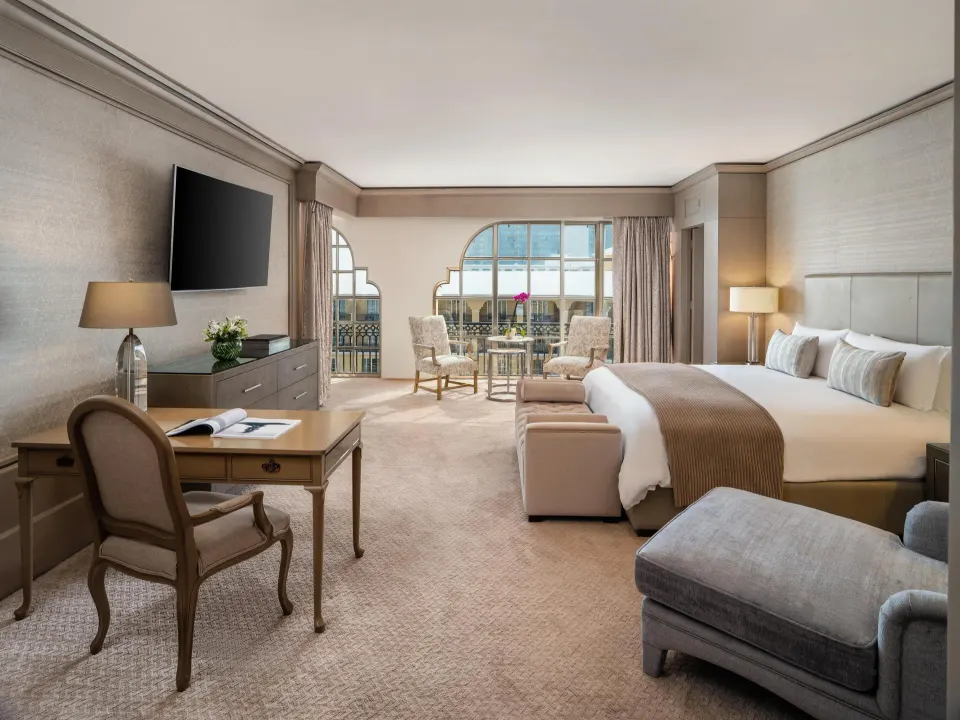 Presidential Suite king bedroom with desk, TV and balcony seating at Kempinski Hotel Cancún.