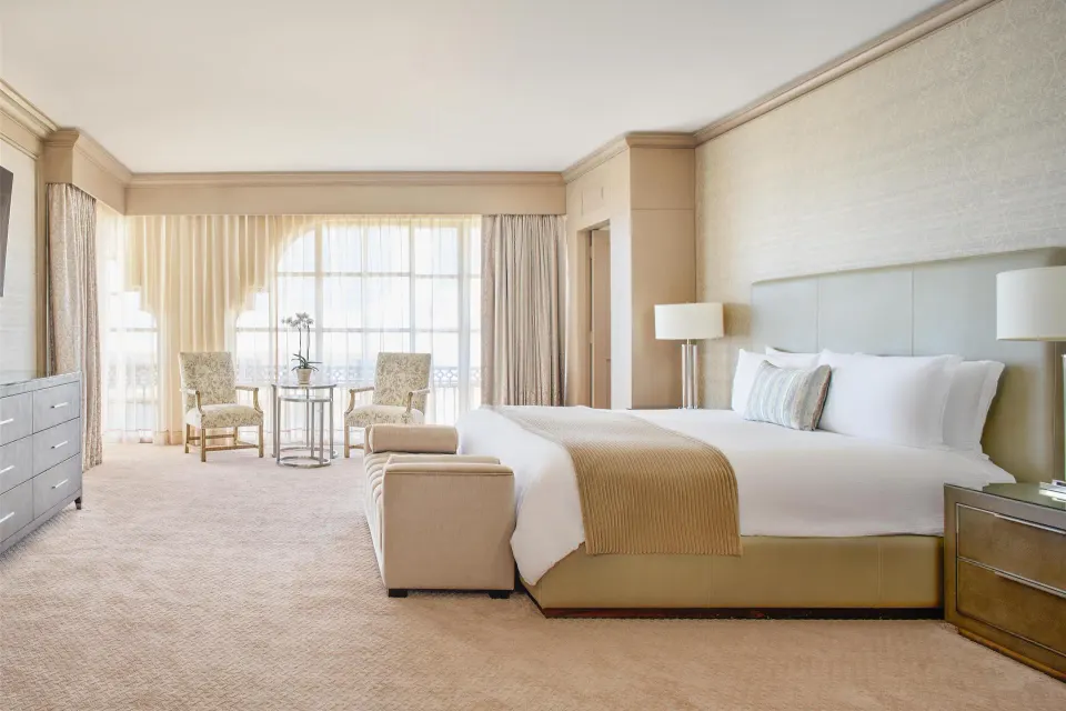 Presidential Suite king bed with bench and window seating at Kempinski Hotel Cancún.