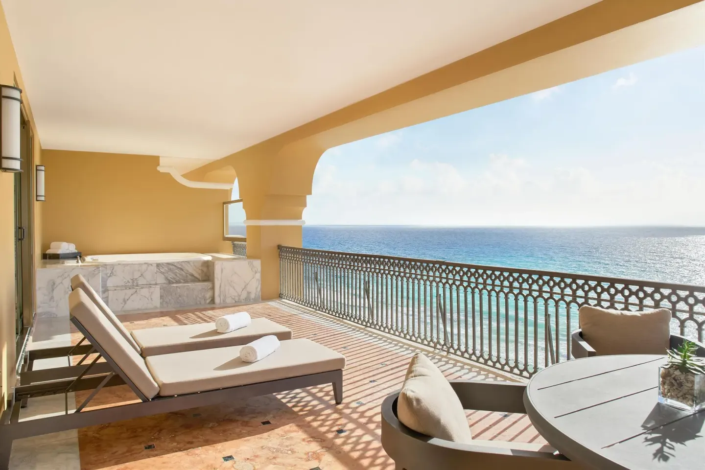 Presidential Suite terrace with loungers, dining table and ocean view at Kempinski Hotel Cancún.