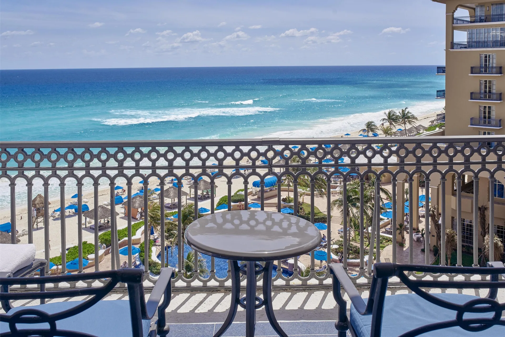 Seaside Suite balcony with table, chairs, ocean and beach views at Kempinski Hotel Cancún.
