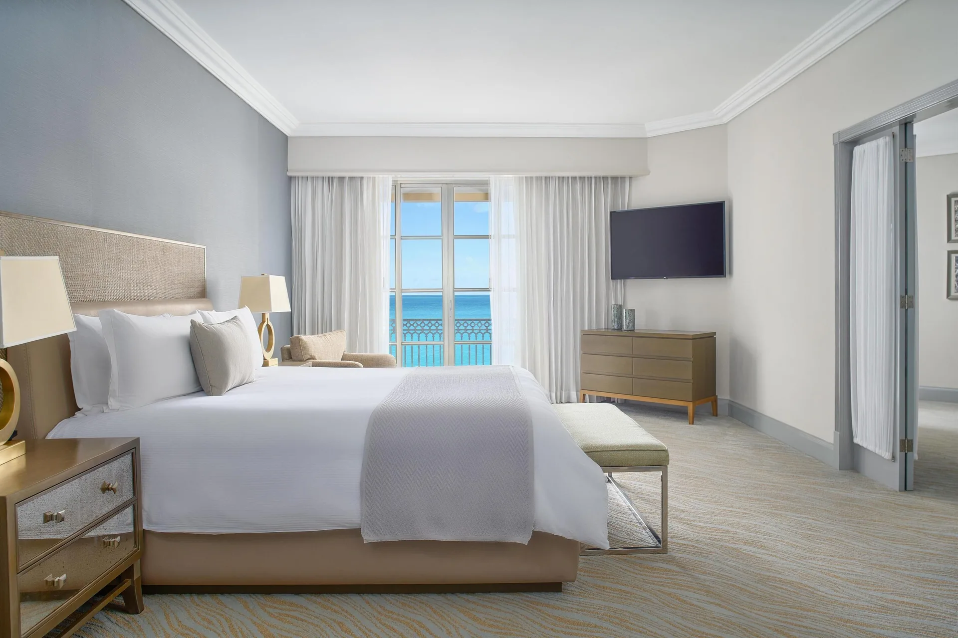 Seaside Suite king bedroom at Kempinski Hotel Cancún with private balcony, elegant décor, and Caribbean Sea views in Cancún's Hotel Zone.