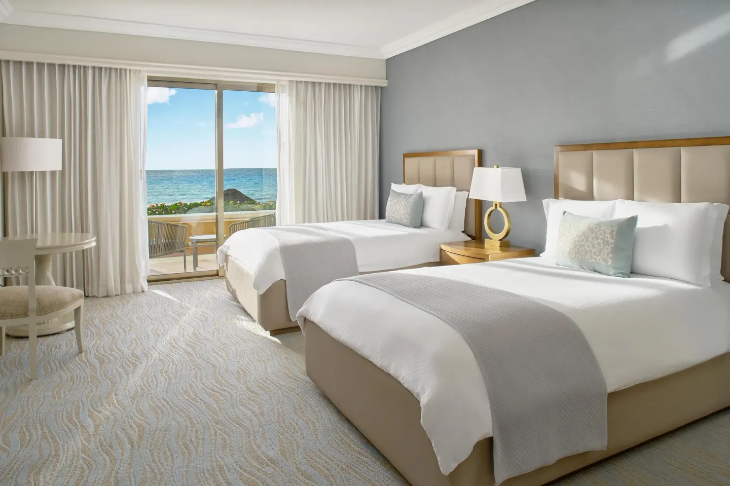 Saasil Suite bedroom with two double beds and a sea-facing balcony at Kempinski Hotel Cancún.