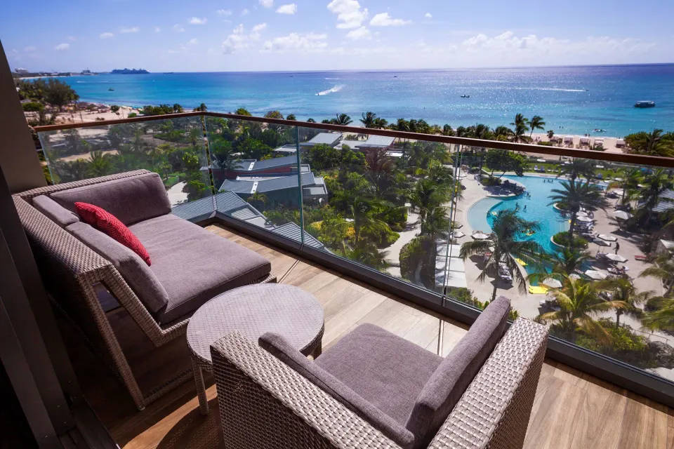 Balcony seating overlooking the pool and beach at Kimpton Seafire Resort + Spa