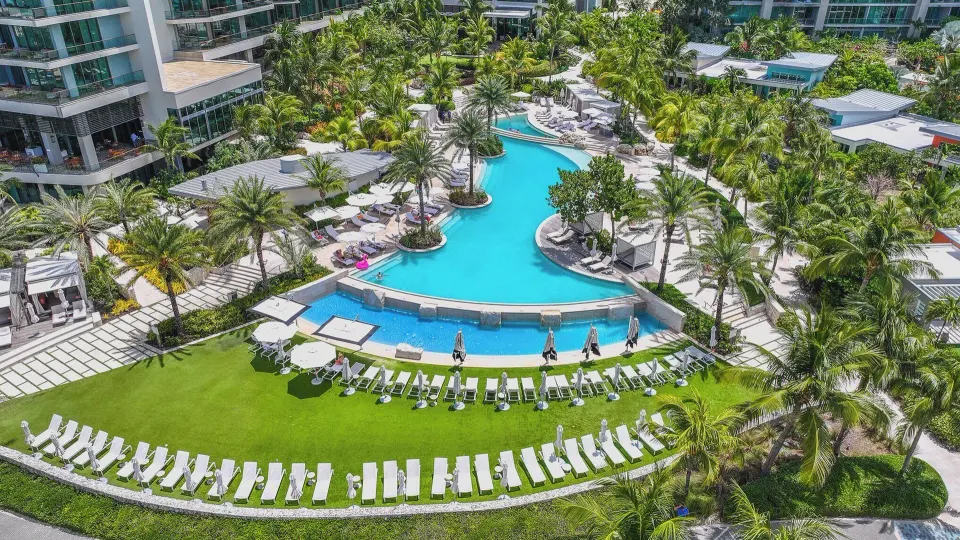Large central lagoon pool with lawn and rows of loungers at Kimpton Seafire Resort + Spa