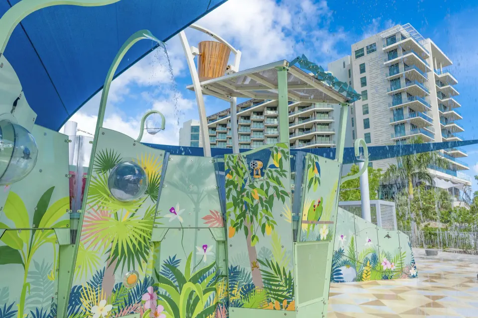Colorful kid splash area with painted panels and resort tower in background at Kimpton Seafire Resort + Spa