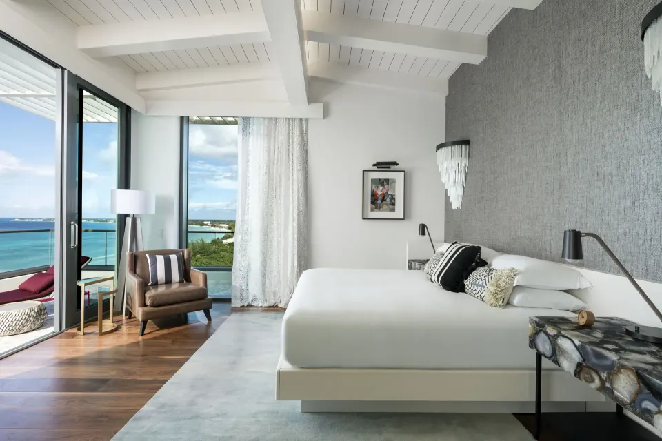 Spacious king bedroom with vaulted ceiling and balcony at Kimpton Seafire Resort + Spa