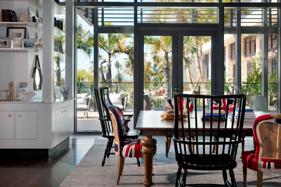 Indoor dining table with mixed chairs and glass doors to a patio at Kimpton Seafire Resort + Spa