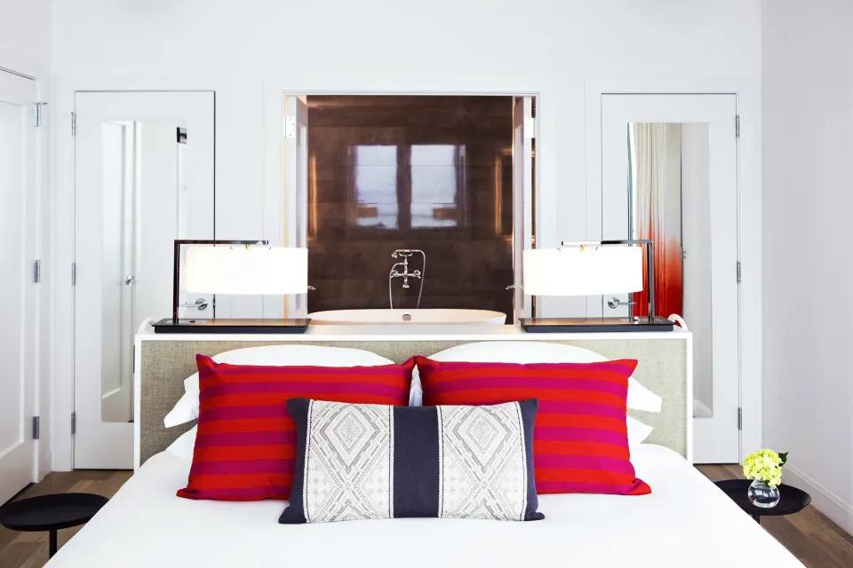 King bed with freestanding tub visible behind the headboard at Kimpton Seafire Resort + Spa