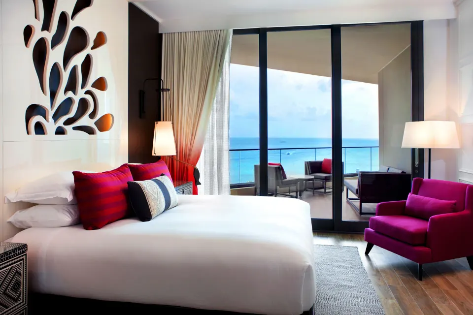 King bed and balcony with ocean view in a guest room at Kimpton Seafire Resort + Spa.