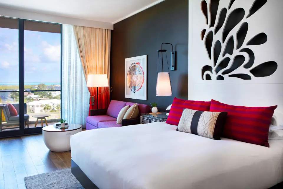 King bed and seating area with balcony view in a guest room at Kimpton Seafire Resort + Spa