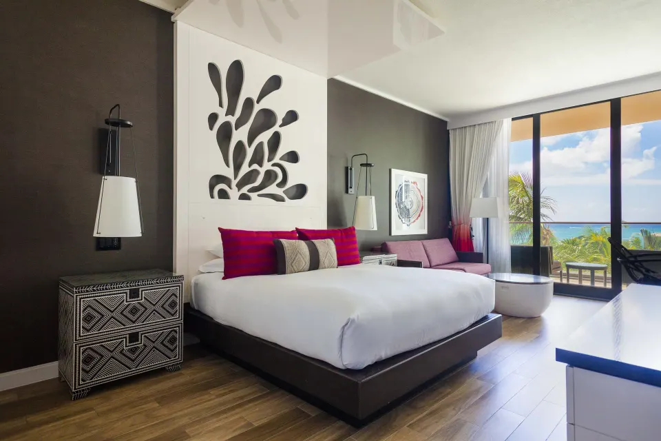 King bed and balcony view with palm trees at Kimpton Seafire Resort + Spa