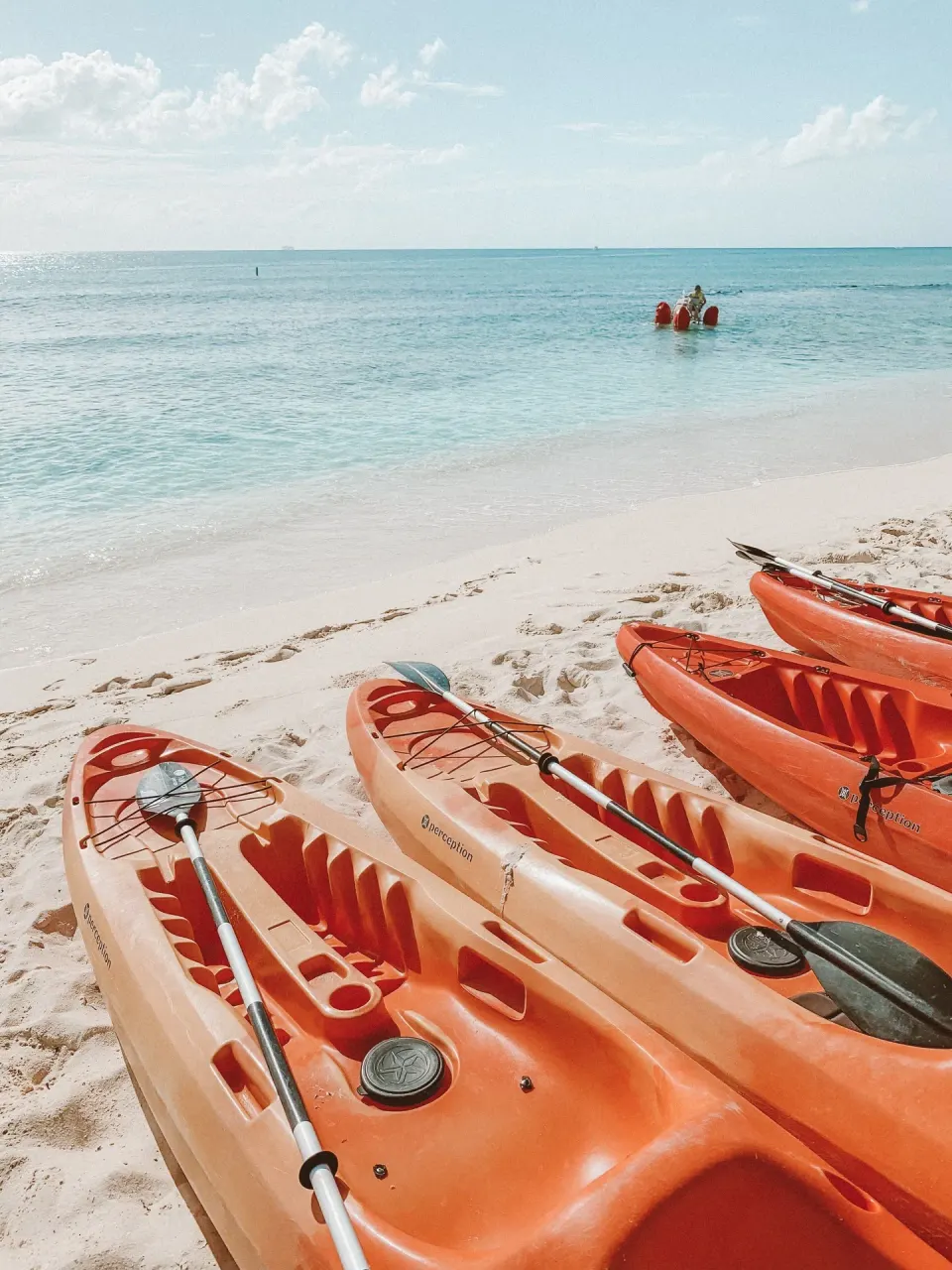 Orange kayaks lined on the sand at Kimpton Seafire Resort + Spa beach