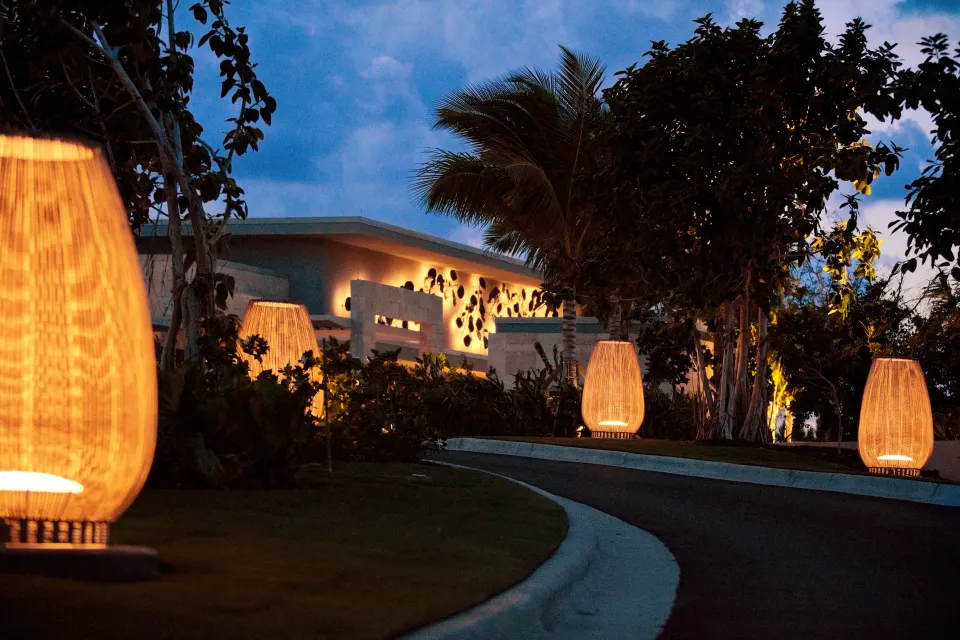 Lit pathway and decorative lanterns leading to Kimpton Seafire Resort + Spa at dusk