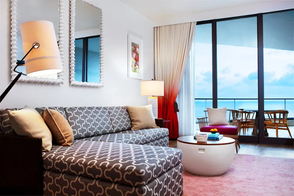 Living area with patterned chaise and balcony at Kimpton Seafire Resort + Spa.