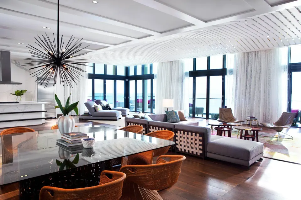 Large open living and dining area with ocean-facing windows at Kimpton Seafire Resort + Spa