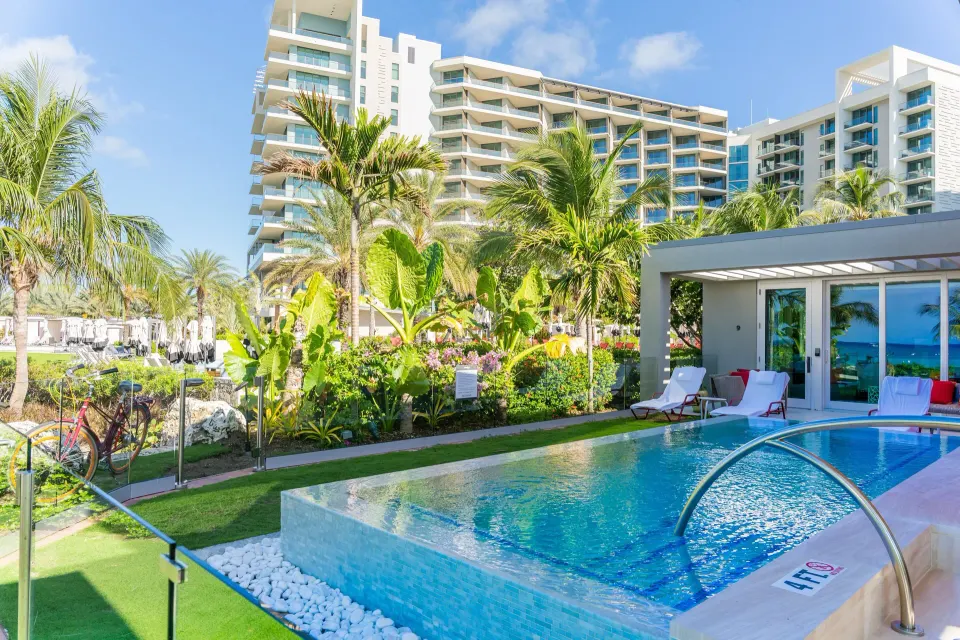 Outdoor pool with glass edge and resort tower at Kimpton Seafire Resort + Spa