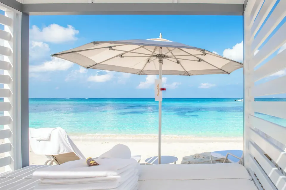 Private cabana bed with umbrella looking out to turquoise water at Kimpton Seafire Resort + Spa