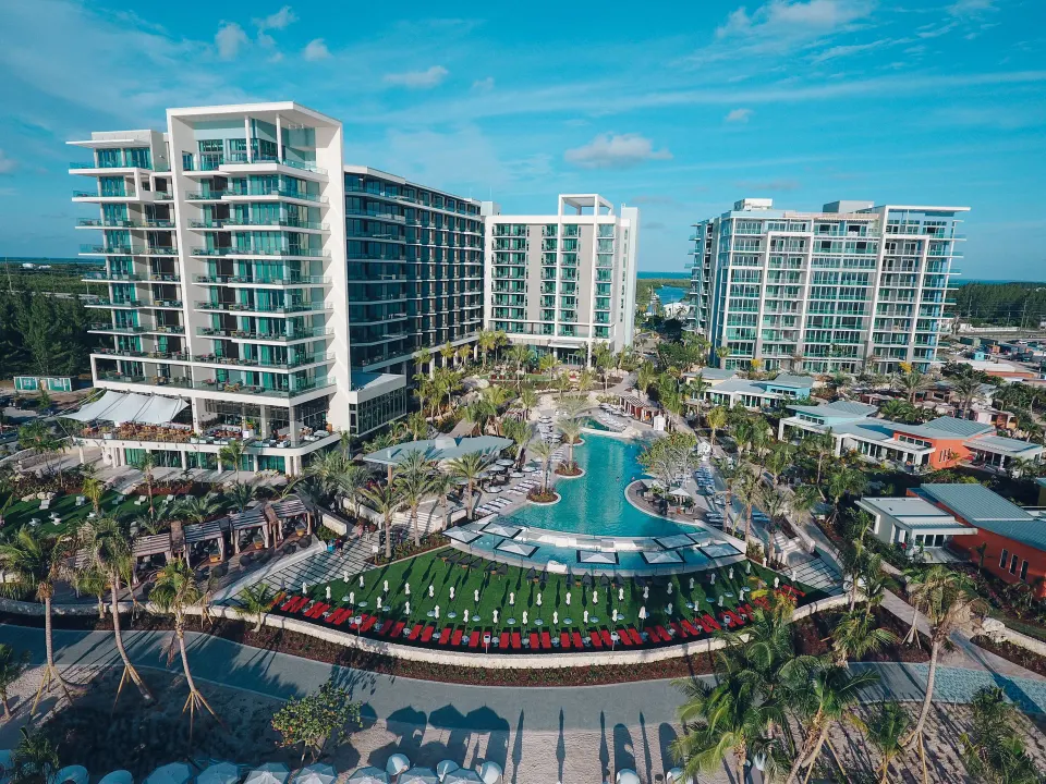 Front view of Kimpton Seafire Resort + Spa with central lagoon-style pool and landscaped lawns