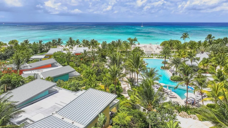 Resort rooftops and lush gardens with pool and beach in the distance at Kimpton Seafire Resort + Spa