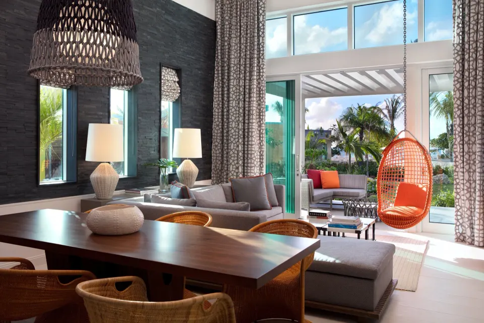 Suite living and dining area with hanging chair and garden view at Kimpton Seafire Resort + Spa