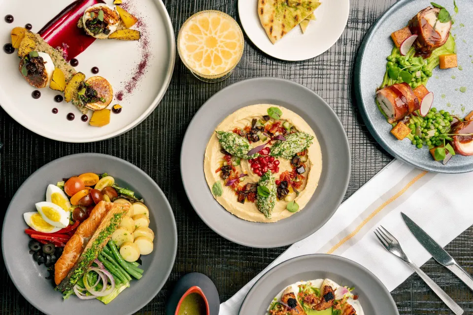 Assortment of plated dishes arranged on a table at Kimpton Seafire Resort + Spa