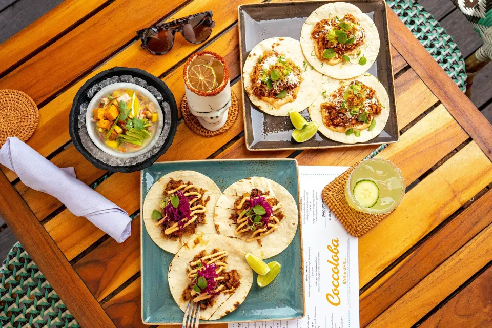 Top-down table of tacos, ceviche and cocktails at Coccoloba at Kimpton Seafire Resort + Spa.