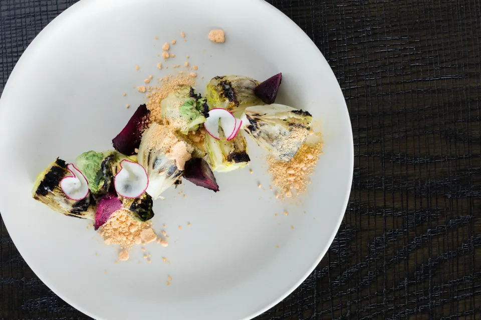 Composed vegetable and radish dish on a white plate at Kimpton Seafire Resort + Spa