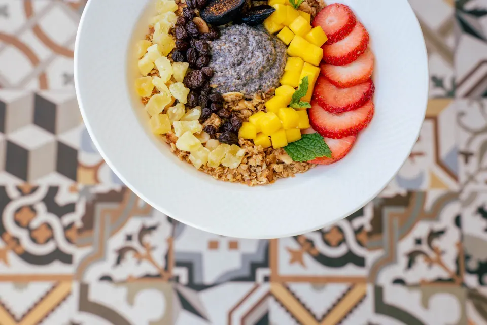 Breakfast grain bowl with fruit and granola on patterned tile at Kimpton Seafire Resort + Spa