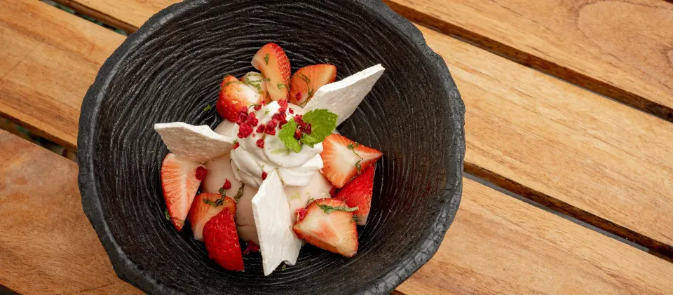 Strawberry dessert with cream in a black bowl at Kimpton Seafire Resort + Spa.