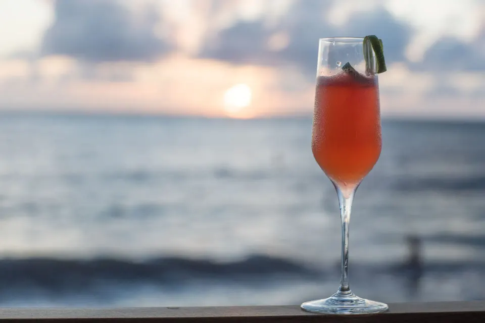 Single sunset cocktail on a railing with the ocean behind at Kimpton Seafire Resort + Spa