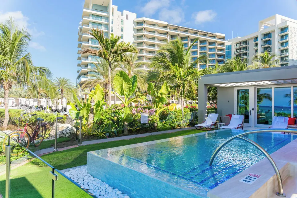 Outdoor plunge pool and landscaped lawn with Kimpton Seafire Resort + Spa tower in the background