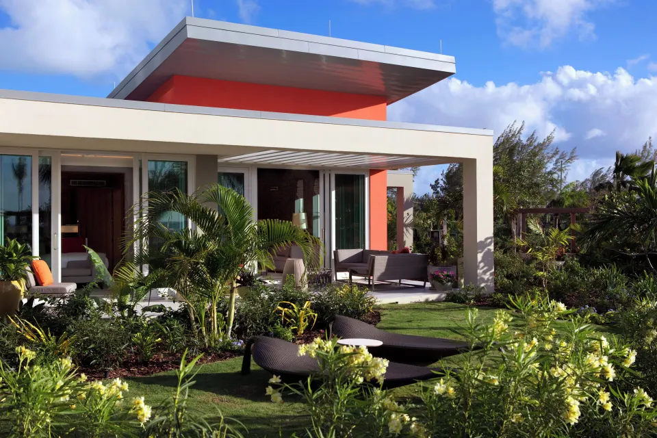 Garden View bungalow exterior with patio seating and palm plantings at Kimpton Seafire Resort + Spa