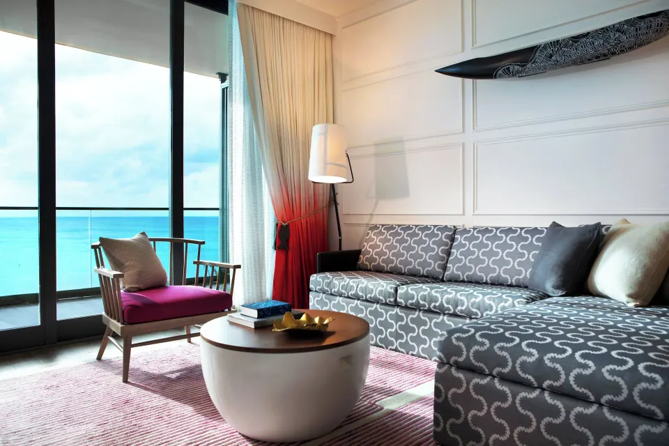 Ocean View One-Bedroom Suite cozy lounge with patterned chaise and ocean balcony at Kimpton Seafire Resort + Spa