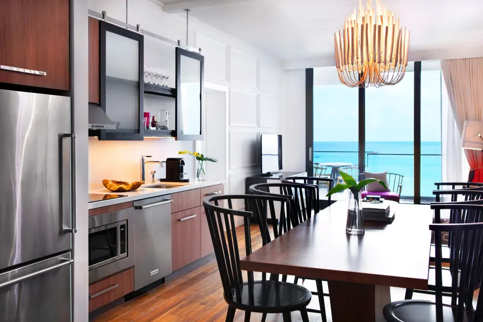 Dining table and kitchenette with ocean view in an Oceanfront One-Bedroom Suite at Kimpton Seafire Resort + Spa