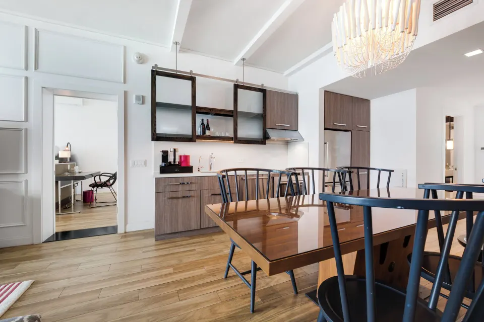 Dining area and kitchenette with open doorway to bedroom in an Oceanfront One-Bedroom Suite at Kimpton Seafire Resort + Spa