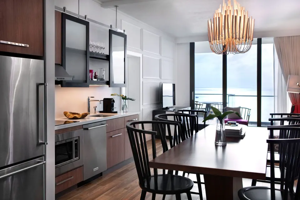 Kitchenette and dining table with ocean backdrop in an Oceanfront One-Bedroom Suite at Kimpton Seafire Resort + Spa
