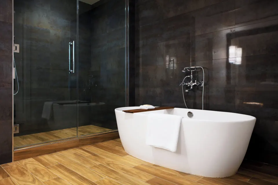 Soaking tub beside glass shower in an Oceanfront One-Bedroom Suite bathroom at Kimpton Seafire Resort + Spa