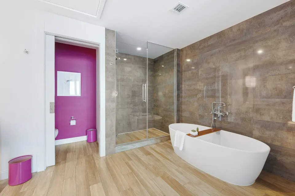Spacious bathroom with walk-in shower and freestanding tub in Oceanfront One-Bedroom Suite at Kimpton Seafire Resort + Spa