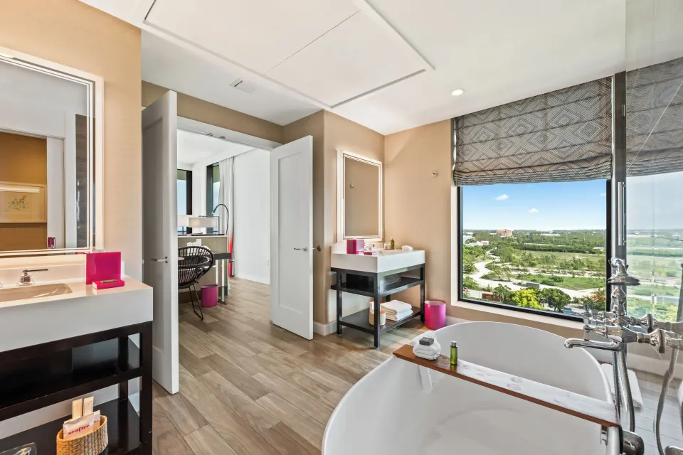 Freestanding tub and dual vanities with large window view in Oceanfront One-Bedroom Suite at Kimpton Seafire Resort + Spa