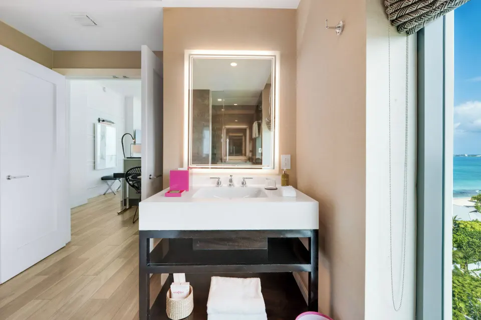 Bathroom sink and framed mirror with ocean view in Oceanfront One-Bedroom Suite at Kimpton Seafire Resort + Spa